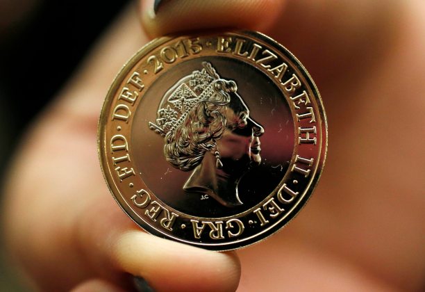 A gallery assistant holds a 2-pound coin with the new portrait of Britain's Queen Elizabeth following it's unveiling at the National Portrait Gallery in London