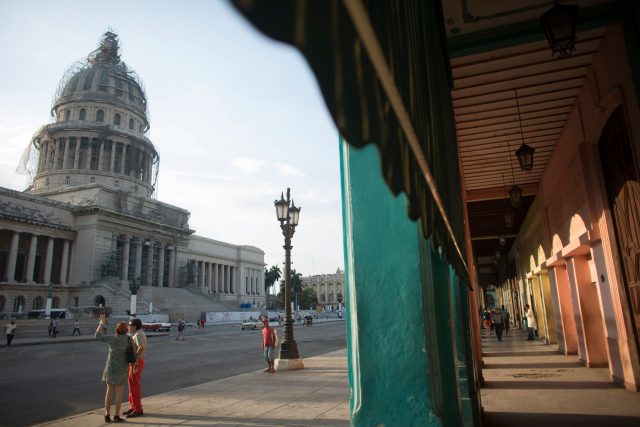Tourists stand near the Capitol in Havana