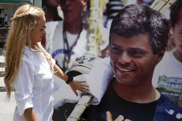 Lilian Tintori, wife of Venezuela's jailed opposition leader Leopoldo Lopez, looks at and touches a picture of him, during a gathering to celebrate the birthday of her husband in Caracas