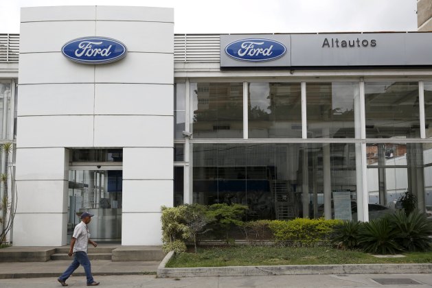 A man walks past a Ford branch in Caracas