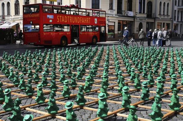 Foto: Un autobús estaciona frente a la instalación "Einheitsmaennchen", del artista conceptual Ottmar Hoerl, en Schwerin (Alemania), hoy, 20 de julio de 2015. La obra, compuesta por más de 1.000 figuras de plástico, fue presentada con motivo del 25 aniversario de la Reunificación alemana / EFE