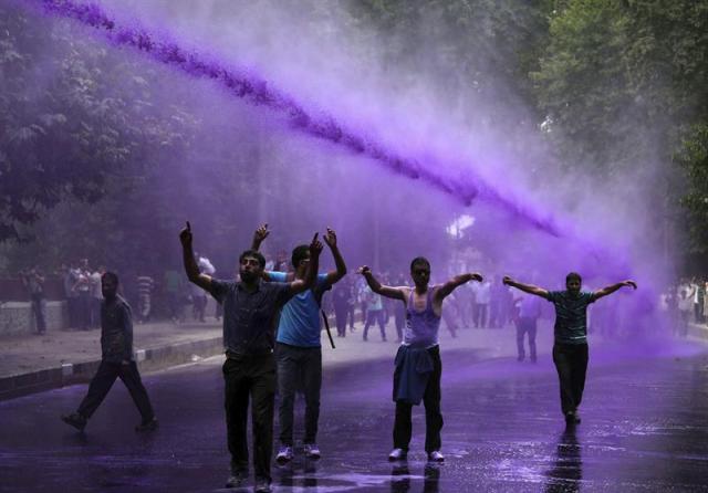 Empleados públicos gritan consignas mientras la policía dispersa la manifestación con cañones de agua en Srinagar, capital de verano de la Cachemira india, hoy 10 de agosto de 2015. Los empleados públicos exigen una regularización de sus empleos y el pago de sus salarios pendientes. EFE/Farooq Khan