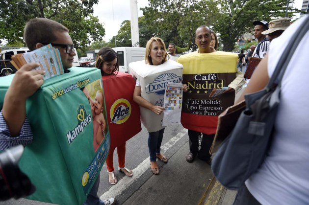 People disguised as boxes of products which are becoming scarce, protest during a demo against shortage in Caracas on November 6, 2015. Hit by an economic crisis without precedent, Venezuelans will come to a crucial parliamentary election in a month, in which the opposition threatens to win a majority for the first time in 16 years.  AFP  PHOTO/JUAN BARRETO