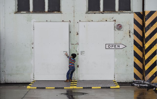 Un niño intenta abrir una puerta en un refigio de Berlín  AFP PHOTO / TOBIAS SCHWARZ 