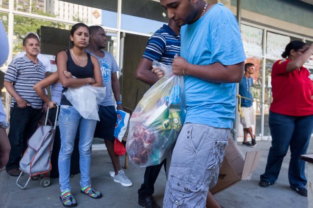 CAR01. CARACAS (VENEZUELA), 23/01/2016.- Un hombre carga una bolsa con alimentos hoy, sábado 23 de enero de 2016, en la ciudad de Caracas (Venezuela). El presidente del Parlamento venezolano, el opositor Henry Ramos Allup, reiteró hoy que los problemas que afronta su país con una aguda crisis económica de carestía y escasez se agravarán si Nicolás Maduro sigue en la jefatura del Estado. La situación económica del quinto productor de petróleo del mundo se ha visto golpeada por la caída de los precios del crudo, que inició en septiembre de 2014 cuando se cotizaba en 90 dólares por barril y que cerró esta semana en 21,63 dólares. "Este Gobierno va a resolver nada; mientras esté allí todos los problemas de Venezuela van a empeorar totalmente. Hasta que no salgamos democráticamente de este Gobierno, Venezuela no se va a recuperar ni podrá resolver ninguno de sus problemas", subrayó en un discurso ante manifestantes antigubernamentales en Caracas. EFE/MIGUEL GUTIERREZ