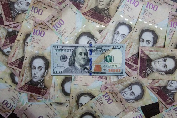 CAR01. CARACAS (VENEZUELA), 17/02/2016.- Fotografía de billetes de pesos venezolanos y dólares estadounidenses hoy, miércoles 17 de febrero de 2016, en Caracas (Venezuela). El presidente venezolano, Nicolás Maduro, anunció hoy una serie de medidas económicas que incluye el primer aumento del precio de la gasolina en el país en 27 años, que sube más de un 6.000 %, una devaluación del bolívar del 58,7 % y un aumento del 20 % de los salarios básicos. EFE/Miguel Gutiérrez