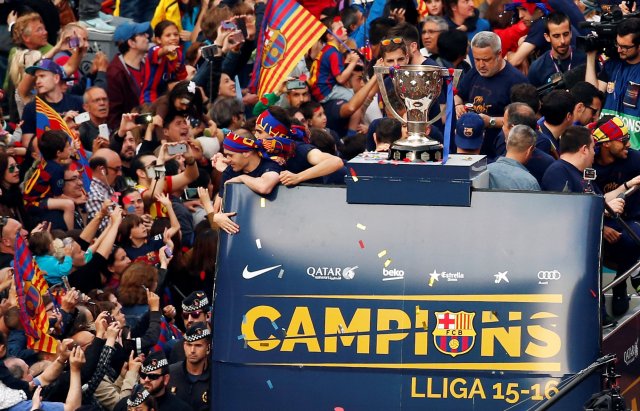 Barcelona's players and staff members on an open-top bus celebrate with their supporters during a parade along the streets of Barcelona, after winning the Spanish Liga, in Barcelona, Spain, May 15, 2016. REUTERS/Albert Gea TPX IMAGES OF THE DAY