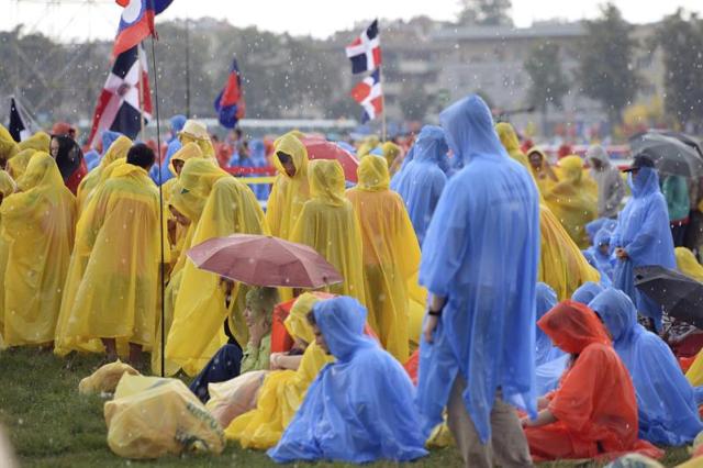 Varios peregrinos esperan bajo la lluvia para la misa inaugural de la XXXI Jornada Mundial de la Juventud (JMJ) en Cracovia, Polonia, hoy 26 de julio de 2016. La nueva edición de la Jornada Mundial de la Juventud comienza hoy y finaliza el próximo 31 de julio. El papa Francisco viaja desde el 27 al 31 de julio a Polonia para asistir a la JMJ y visitará los lugares símbolos de Juan Pablo II y recordará el Holocausto con un recorrido en silencio por los campos de Auschwitz y Bikernau. EFE/Maciej Kulczynsk