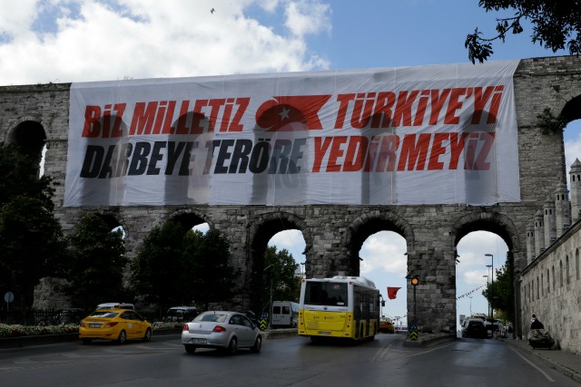 Vehículos pasan por debajo del acueducto de Valens, donde una pancarta dice 'Somos la nación, no dejaremos que Turquía caiga por golpes de Estado y terrorismo', en Estambul, el 15 de agosto de 2016. (AP Foto/Thanassis Stavrakis)