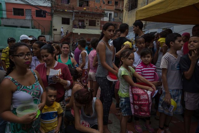 CAR04. CARACAS (VENEZUELA), 10/09/2016.- Habitantes esperan para recibir porciones de un sancocho hoy, sábado 10 de septiembre del 2016, en la ciudad de Caracas (Venezuela). En el barrio la Unión, ubicado en la favela más grande de América Latina asentada en el este de Caracas, se preparó hoy un gran "sancocho" como se le conoce en Venezuela a la sopa cocinada con varios tipos de verduras y carnes, para alimentar a los vecinos, muchos de ellos con varios días de hambre. EFE/MIGUEL GUTIÉRREZ