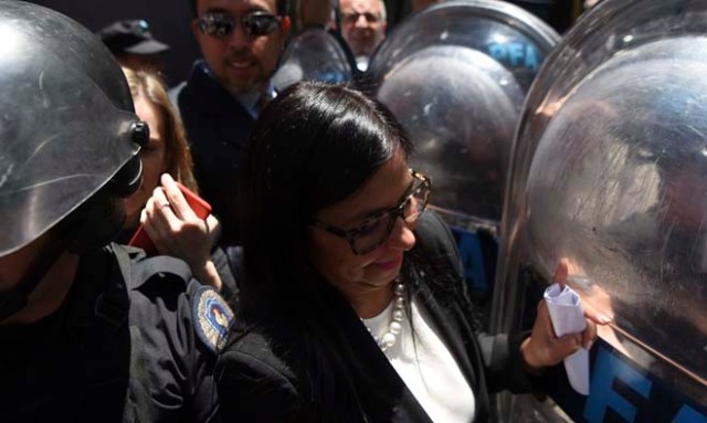 Venezuela's Foreign Minister Delcy Rodriguez, is blocked by riot police officers before entering the Argentine Foreign Ministry in Buenos Aires during a meeting among Mercosur's ministers where Venezuela was not invited, on December 14, 2016. Mercosur's foreign ministers debate on Venezuela's suspension from the group after accusations that the leftist government in Caracas failed to meet democratic and trade standards. / AFP PHOTO / EITAN ABRAMOVICH