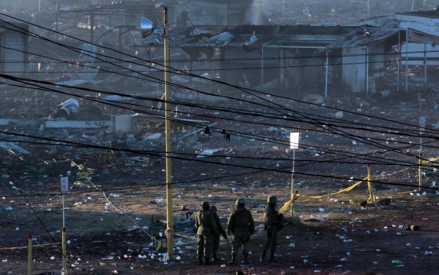 Security forces are seen on December 21, 2016 at Mexico's biggest fireworks market in Mexico City's Tultepec suburb after a massive explosion killed at least 31 people on the eve. The explosion killed at least 31 people and injured 72, authorities said. The conflagration in the Mexico City suburb of Tultepec set off a quick-fire series of multicolored blasts that sent a vast cloud of smoke billowing over the capital. / AFP PHOTO / Pedro PARDO