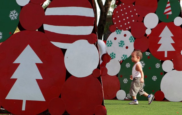 A child runs between the Christmas trees during Christmas eve in Pasay city, Metro Manila, Philippines December 24, 2016. REUTERS/ Czar Dancel