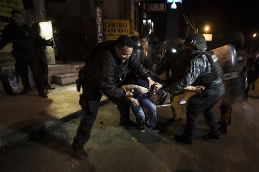 En esta fotografía del sábado 7 de enero de 2017, varios policías detienen a un manifestante que participaba en el bloqueo de un centro de distribución de combustible en Rosarito, cerca de Tijuana, México. La protesta contra el alza de 20% a la gasolina devino en un acto de violencia en el que un manifestante arrolló con una camioneta a varios policías que resguardaban una terminal de distribución de combustible en Baja California. La policía federal dijo que siete policías resultaron lesionados en el incidente. (AP Foto/Hans-Maximo Musielik)