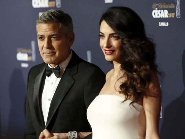 Actor George Clooney and his wife Amal pose as they arrive at the 42nd Cesar Awards ceremony in Paris, France, February 24, 2017. REUTERS/Gonzalo Fuentes