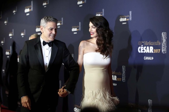 Actor George Clooney and his wife Amal pose as they arrive at the 42nd Cesar Awards ceremony in Paris, France, February 24, 2017. REUTERS/Gonzalo Fuentes