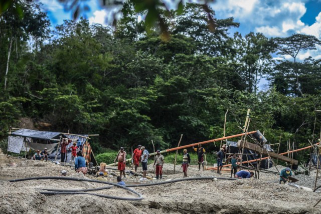 Men work at a gold mine on the banks of a river in El Callao, Bolivar state, southeastern Venezuela on February 24, 2017. Although life in the mines of eastern Venezuela is hard and dangerous, tens of thousands from all over the country head for the mines daily in overcrowded trucks, pushed by the rise in gold prices and by the severe economic crisis affecting the country, aggravated recently by the drop in oil prices. / AFP PHOTO / JUAN BARRETO / TO GO WITH AFP STORY by Maria Isabel SANCHEZ