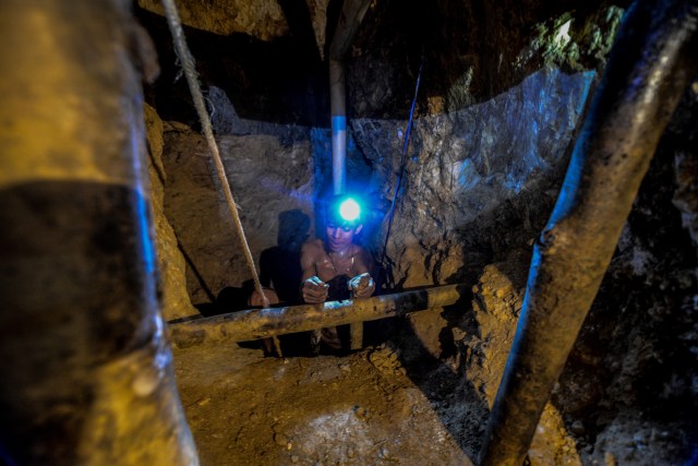 Ender Moreno descends looking for gold at La Culebra gold mine in El Callao, Bolivar state, southeastern Venezuela on March 1, 2017. Although life in the mines of eastern Venezuela is hard and dangerous, tens of thousands from all over the country head for the mines daily in overcrowded trucks, pushed by the rise in gold prices and by the severe economic crisis affecting the country, aggravated recently by the drop in oil prices. / AFP PHOTO / JUAN BARRETO / TO GO WITH AFP STORY by Maria Isabel SANCHEZ