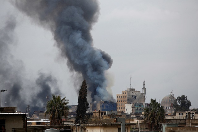 El humo se eleva sobre una calle al oeste de Mosul