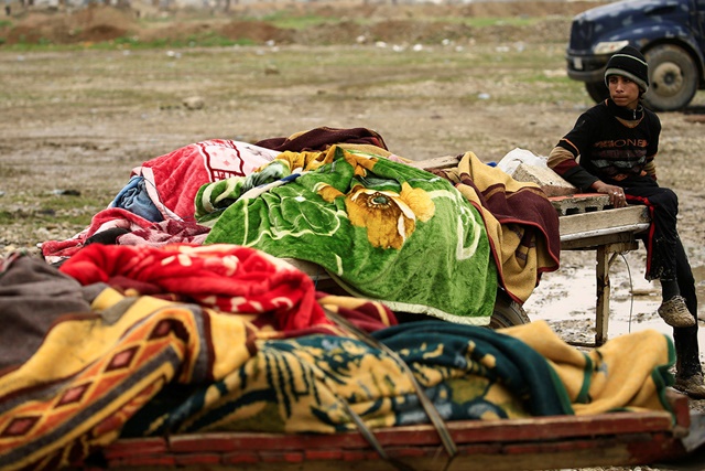 Familiares cargando los cuerpos de los muertos en ataques aéreos en Mosul
