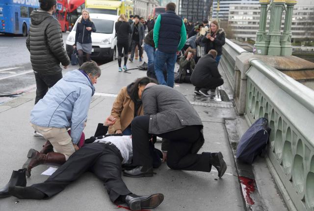 Unas personas heridas reciben asistencia tras un incidente en el puente de Westminster en Londres, mar 22, 2017. Un policía fue apuñalado, un atacante fue abatido a tiros y varias personas resultaron heridas el miércoles cerca del Parlamento en Londres, en un suceso que está siendo tratado como un "incidente terrorista" por la policía. REUTERS/Toby Melville