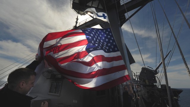 La bandera estadounidense durante una misa católica a bordo del portaaviones USS Carl Vinson.
