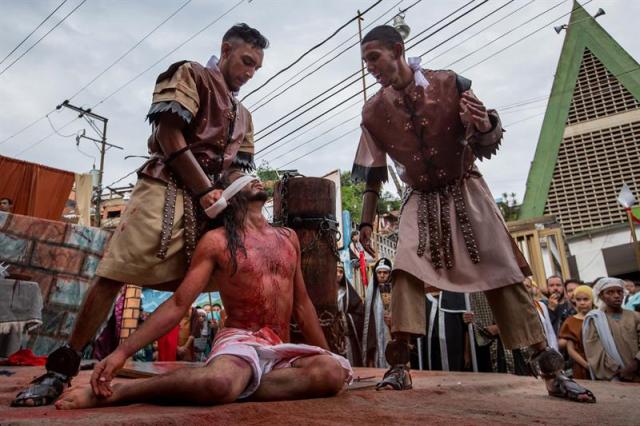 Un grupo de personas participa en la representación del viacrucis hoy, viernes 14 de abril de 2017, por las calles del barrio Petare en Caracas (Venezuela). EFE/MIGUEL GUTIÉRREZ