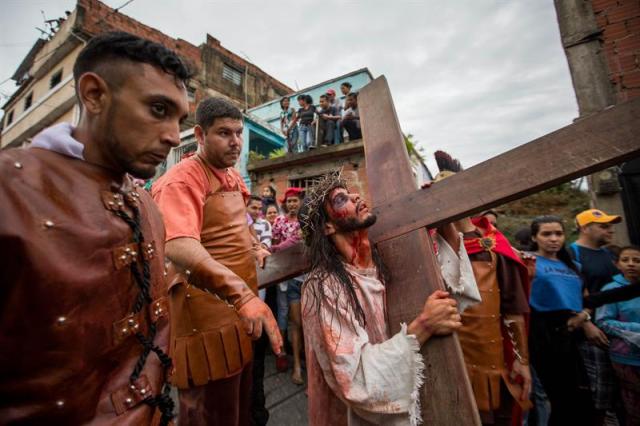 Un grupo de personas participa en la representación del viacrucis hoy, viernes 14 de abril de 2017, por las calles del barrio Petare en Caracas (Venezuela). EFE/MIGUEL GUTIÉRREZ