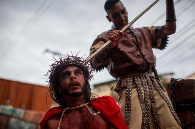 Un grupo de personas participa en la representación del viacrucis hoy, viernes 14 de abril de 2017, por las calles del barrio Petare en Caracas (Venezuela). EFE/MIGUEL GUTIÉRREZ