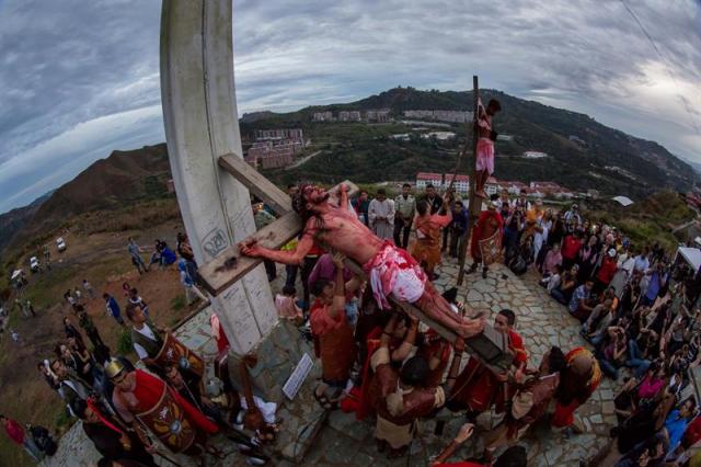 Un grupo de personas participan en la representación del viacrucis hoy, viernes 14 de abril de 2017, por las calles del barrio Petare en Caracas (Venezuela). EFE/MIGUEL GUTIÉRREZ