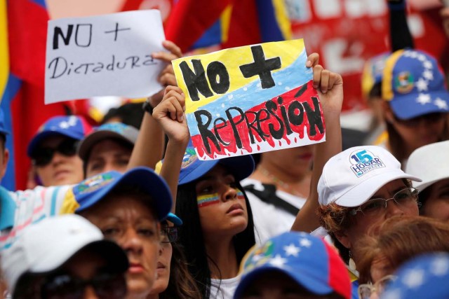 Demonstrators hold placards that read "No more repression" and "No more dictatorship" during a women's march to protest against President Nicolas Maduro's government in Caracas, Venezuela, May 6, 2017. REUTERS/Carlos Garcia Rawlins