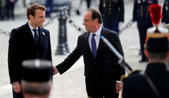 Outgoing French President Francois Hollande (R) and President-elect Emmanuel Macron attend a ceremony to mark the end of World War II at the Tomb of the Unknown Soldier at the Arc de Triomphe in Paris, France, May 8, 2017. REUTERS/Philippe Wojazer