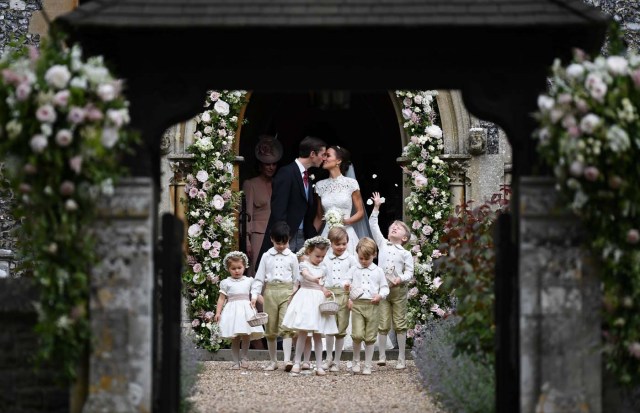 Pippa Middleton kisses her new husband James Matthews, following their wedding ceremony at St Mark's Church, as the bridesmaids, including Britain's Princess Charlotte and pageboys, including Prince George, walk ahead, in Englefield, Britain May 20, 2017. REUTERS/Justin Tallis/Pool