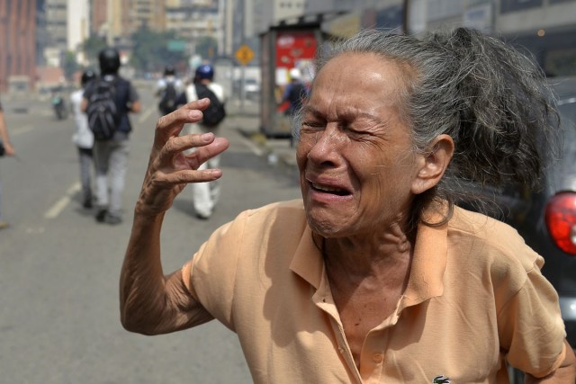 An opposition demonstrator gestures in clashes with the riot police during the "Towards Victory" protest against the government of Nicolas Maduro, in Caracas on June 10, 2017.  Clashes at near daily protests by demonstrators calling for Maduro to quit have left 66 people dead since April 1, prosecutors say.  / AFP PHOTO / LUIS ROBAYO