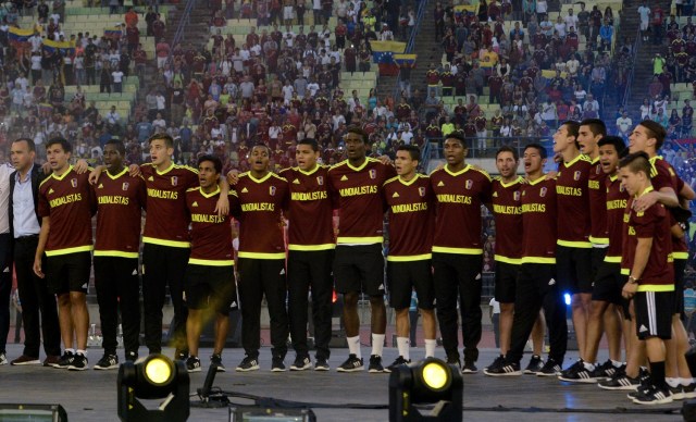 Rafael Dudamel (L), entrenador de la selección venezolana Sub-20, subcampeón de la Copa Mundial Sub-20 en Corea del Sur, y los jugadores escuchan su himno nacional durante una reunión en el Estadio Olímpico de la Central Universidad de Venezuela para darles la bienvenida, en Caracas, el 13 de junio de 2017. / AFP PHOTO / Federico PARRA