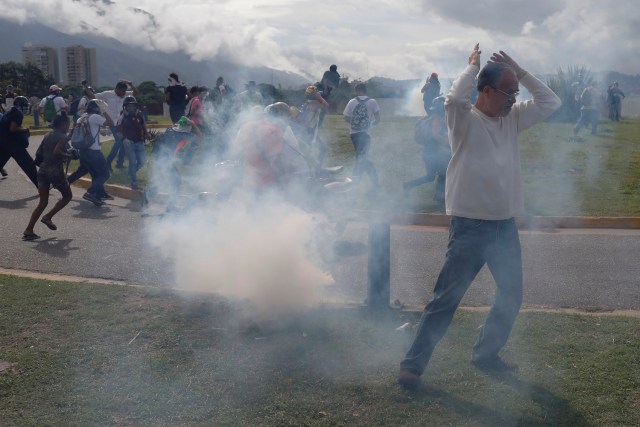 Demonstrators run away from tear gas as they clash with riot security forces during a protest against Venezuelan President Nicolas Maduro's government in Caracas, Venezuela June 5, 2017. REUTERS/Marco Bello