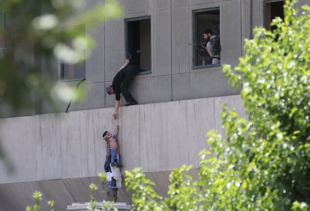 A boy is evacuated during an attack on the Iranian parliament in central Tehran, Iran, June 7, 2017. Omid Vahabzadeh/TIMA via REUTERS ATTENTION EDITORS - THIS IMAGE WAS PROVIDED BY A THIRD PARTY. FOR EDITORIAL USE ONLY.