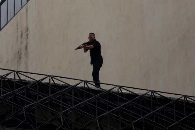 A man aims his weapon toward demonstrators (not pictured)as they attack a Supreme Justice Court branch during riots at a rally against Venezuelan president Nicolas Maduro's government in Caracas, Venezuela, June 7, 2017. REUTERS/Marco Bello