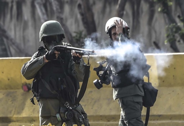 Members of the National Guard charge on opposition activists during protests against Venezuelan President Nicolas Maduro in Caracas on July 10, 2017.  Venezuela hit its 100th day of anti-government protests Sunday, amid uncertainty over whether the release from prison a day earlier of prominent political prisoner Leopoldo Lopez might open the way to negotiations to defuse the profound crisis gripping the country. / AFP PHOTO / JUAN BARRETO