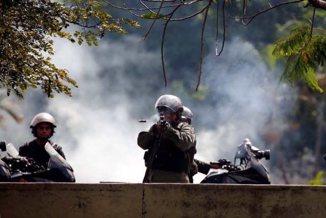 A member of the security forces fires his weapon during a protest against Venezuelan President Nicolas Maduro's government in Caracas, Venezuela July 10, 2017. REUTERS/Carlos Garcia Rawlins