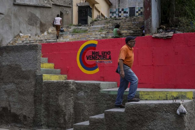 ACOMPAÑA CRÓNICA: VENEZUELA CRISIS - CAR001. CARACAS (VENEZUELA), 15/07/2017.- Un grupo de personas sube las escaleras de una barriada con las paredes decoradas con propaganda de la Asamblea Nacional Constituyente hoy, sábado 15 de julio de 2017, en Caracas (Venezuela). Con el éxito asegurado en las zonas privilegiadas de Caracas, donde el chavismo nunca tuvo predicamento, la consulta opositora sobre la Asamblea Constituyente que impulsa el presidente Nicolás Maduro se la juega ahora en los barrios populares que vieron en Hugo Chávez el mesías de la Revolución Bolivariana. EFE/Miguel Gutiérrez