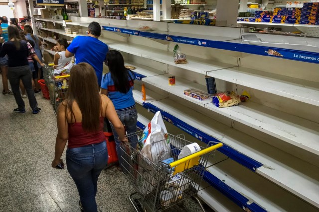 Personas buscan alimentos en un supermercado con estanterías parcialmente vacíos hoy, lunes 24 de julio de 2017, en Caracas (Venezuela). Numerosos supermercados de Caracas cerrarán hoy con más estanterías vacías de lo habitual después de que los habitantes de la capital hicieran acopio de alimentos y otros productos básicos ante el paro general contra el Gobierno que la oposición convocó para el miércoles y el jueves. EFE/MIGUEL GUTIÉRREZ