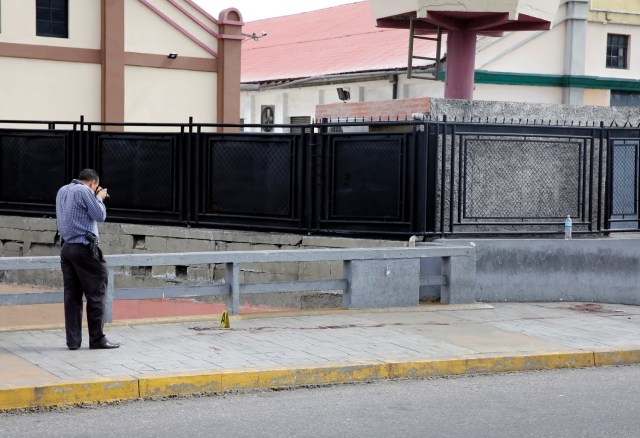 A forensic technician takes photographs at a crime scene where, according to the opposition, gunmen "apparently" shot dead and wounded several people during an opposition-organised unofficial plebiscite against President Nicolas Maduro's government and his plan to rewrite the constitution, in Caracas, Venezuela July 16, 2017. REUTERS/Carlos Garcia Rawlins