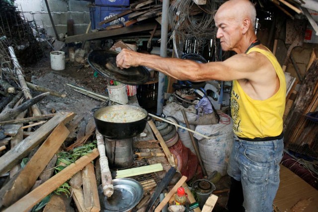 Ipolito Gutierrez cooks the meal using firewood at his house in San Cristobal, Venezuela August 3, 2017. Picture taken August 3, 2017. REUTERS/Luis Parada