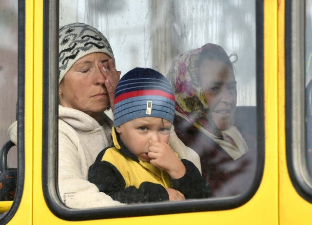 People evacuate from the town of Kalynivka following munition explosions at the nearby military depot on September 27, 2017. Ukranian authorities evacuated nearly 30,000 people September 27 from the central Vinnytsya region after a huge munitions depot caught fire and set off artillery shells and blasts prosecutors were treating as an act of "sabotage". It was the second major incident affecting a Ukrainian weapons storage site this year. Kiev blamed the first one in March on Moscow and its Russian-backed insurgents fighting Ukrainian forces in the war-wrecked east -- a charge both sides denied. / AFP PHOTO / SERGEI SUPINSKY