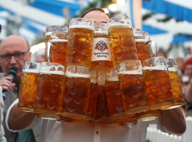 German Oliver Struempfel competes to set a new world record in carrying one liter beer mugs over a distance of 40 m (131 ft 3 in) in Abensberg, Germany September 3, 2017. Struempfel carried 27 mugs over 40 meters to set a new world record. REUTERS/Michael Dalder