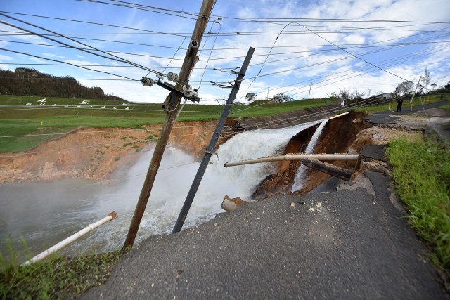 Overflow from the damaged Guajataka River Dam is seen in San Sebastian, in the west of Puerto Rico, on September 23, 2017 following passage of Hurricane Maria, prompting the government to issue an order for 70,000 people in downstream towns to evacuate. Authorities in Puerto Rico rushed to evacuate tens of thousands of people living downriver from a dam said to be in danger of collapsing because of flooding from Hurricane Maria. / AFP PHOTO / HECTOR RETAMAL