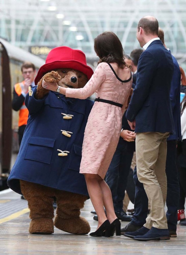 Britain's Prince William watches as his wife Catherine the Duchess of Cambridge dances with a costumed figure of Paddington bear on platform 1 at Paddington Station, as they attend the Charities Forum in London, October 16, 2017. REUTERS/Jonathan Brady/Pool