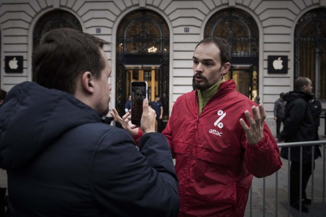 An activist of the "Attac" network speaks during a protest against tax evasion outside an Apple shop on the release day of the new iPhone X in Paris on November 3, 2017. / AFP PHOTO / PHILIPPE LOPEZ