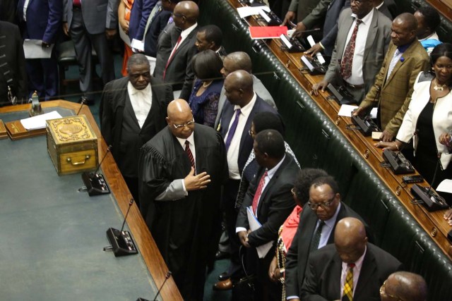 Speaker of the National Assembly Jacob Mudenda (C with black robe) enters the chamber as Zimbabwean Members of Parliament assemble for a parliamentary session where a motion is moved to impeach Zimbabwe President on November 21, 2017 at the Zimbabwean Parliament in Harare. Parliament prepares to start impeachment proceedings against the President, while ousted vice president who could be the country's next leader, tells him to step down. As the 93-year-old autocrat faced intensifying pressure to quit, southern Africa's regional bloc announced it was dispatching the presidents of Angola and South Africa to Harare to discuss the crisis. / AFP PHOTO / POOL / AARON UFUMELI